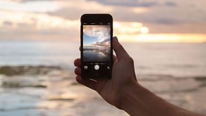 Mit dem Handy ein Foto vom Strand aufnehmen